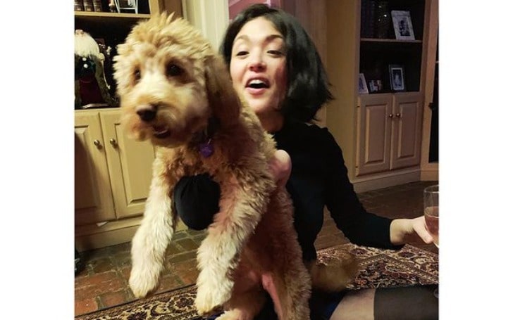 Ellen Tamaki with her pet in a black dress.
